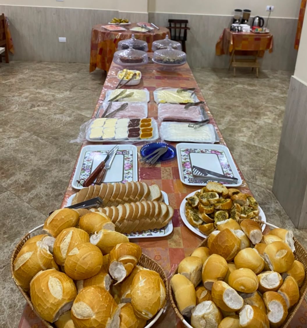 Mesa do café da manhã com pães, frios e queijos