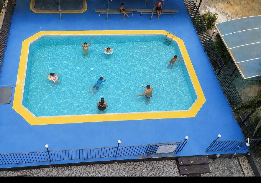 Piscina do hotel com hóspedes se refrescando
